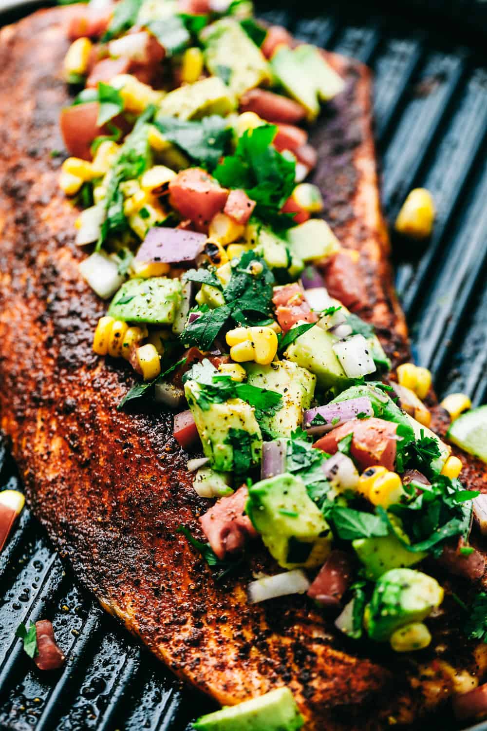 Grilled Salmon with Avocado Salsaย is a tender, juicy grilled salmon, topped with a colorful and flavorfulย combination of avocados, cornย andย tomatoes to make a light and tasty meal. This Salmon is made in minutes for your family!ย Grilled Salmon topped with Avocado Salsa