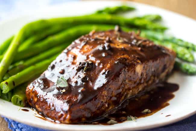 A delicious honey balsamic glaze that makes this salmon incredible! Honey balsamic glaze salmon on a white dish with asparagus on the side.