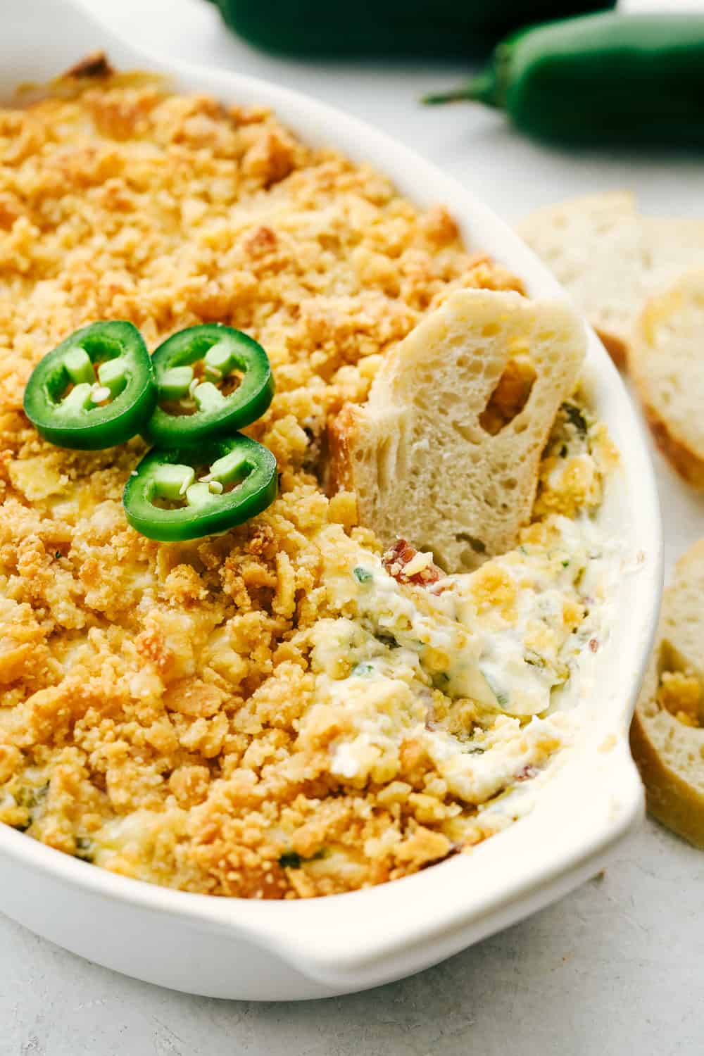 Jalapeno Popper Dip takes all the flavor of the popper and turns it into a creamy, cheesy, easy to eat dip. Super effortless and full of enticing flavors, this dip will be the star of the party!ย Creamy, spicy jalapeno dip with bread for dipping.