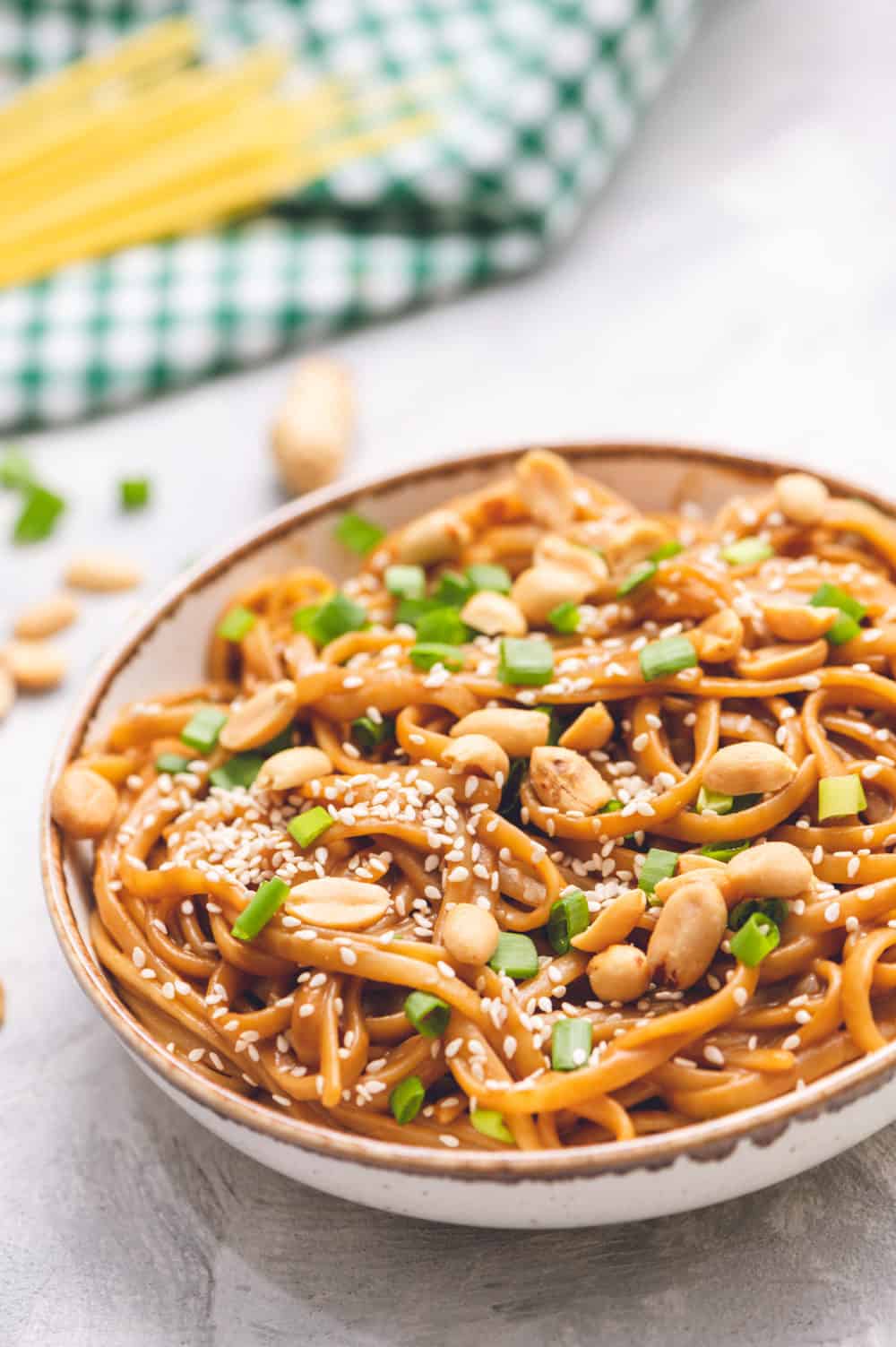 Thai Peanut Sesame Noodlesย is an asianย favorite that combines creamy peanut butter, soy sauce,ย sesame oil, minced garlic all mixed with linguine noodles tossed in this amazingly sweet and savoryย sauce.ย Thai peanut sesame noodles in a bowl with scallops and sesame seeds as garnish.