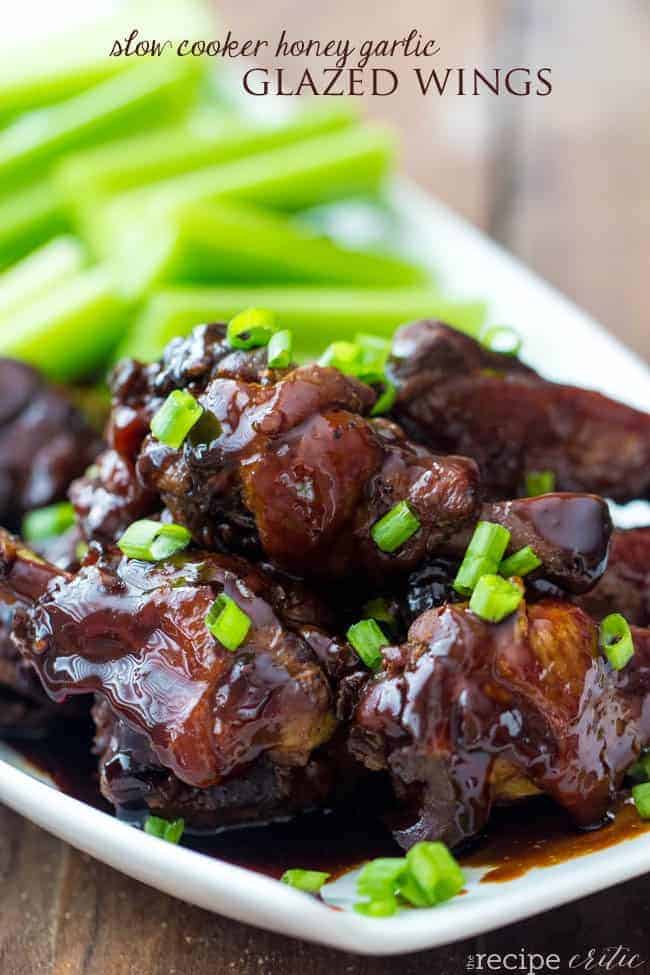 Delicious honey garlic wings that cook perfectly in the slow cooker! Slow cooker honey garlic glazed wings on a white plate.