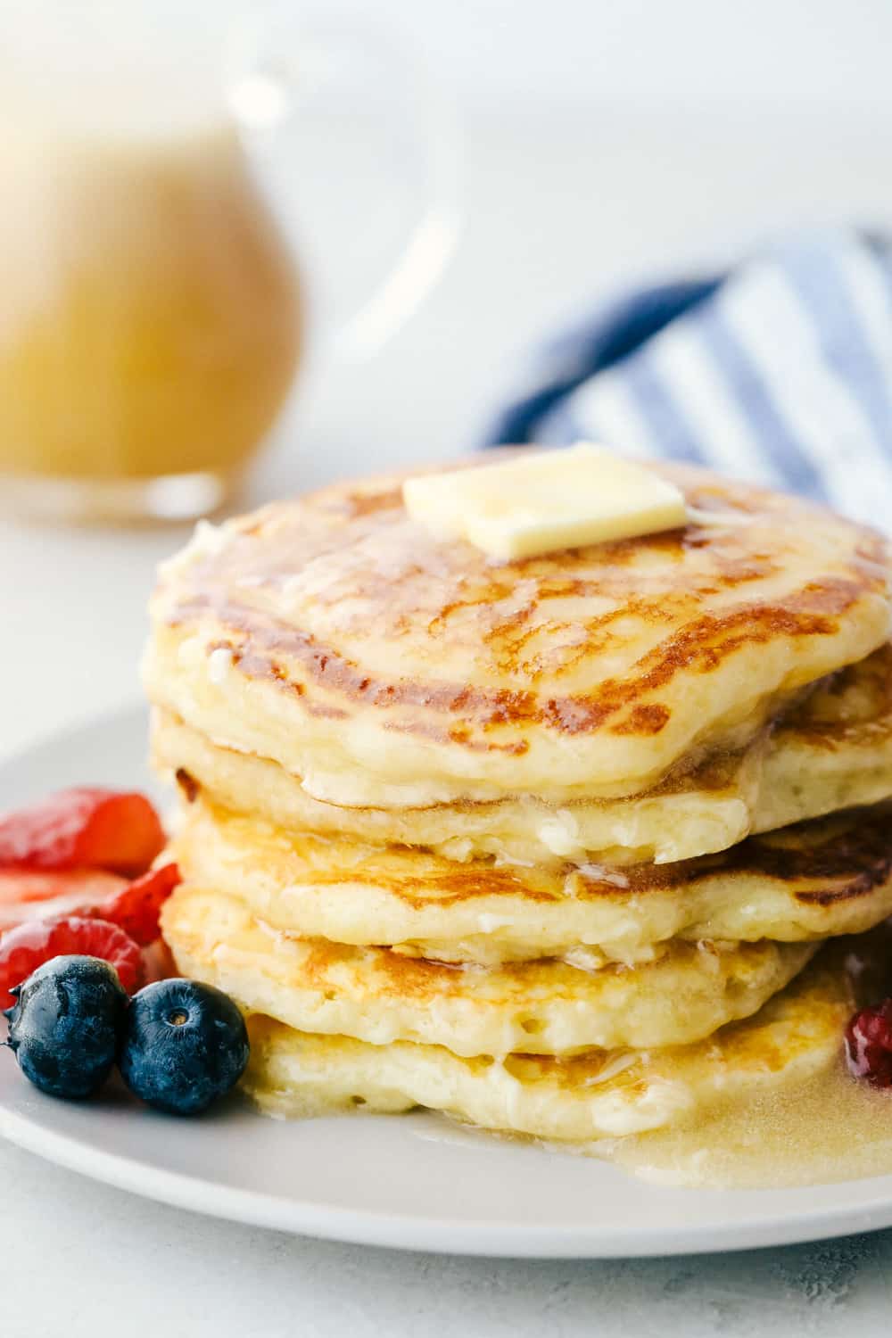The best and only Buttermilk Pancake recipe that you will ever need! Perfectly fluffy every single time! Soft and pillowy with a tender crumb, these are going to be a hit at the breakfast table. Fluffy Buttermilk pancakes on a plate with butter and syrup.