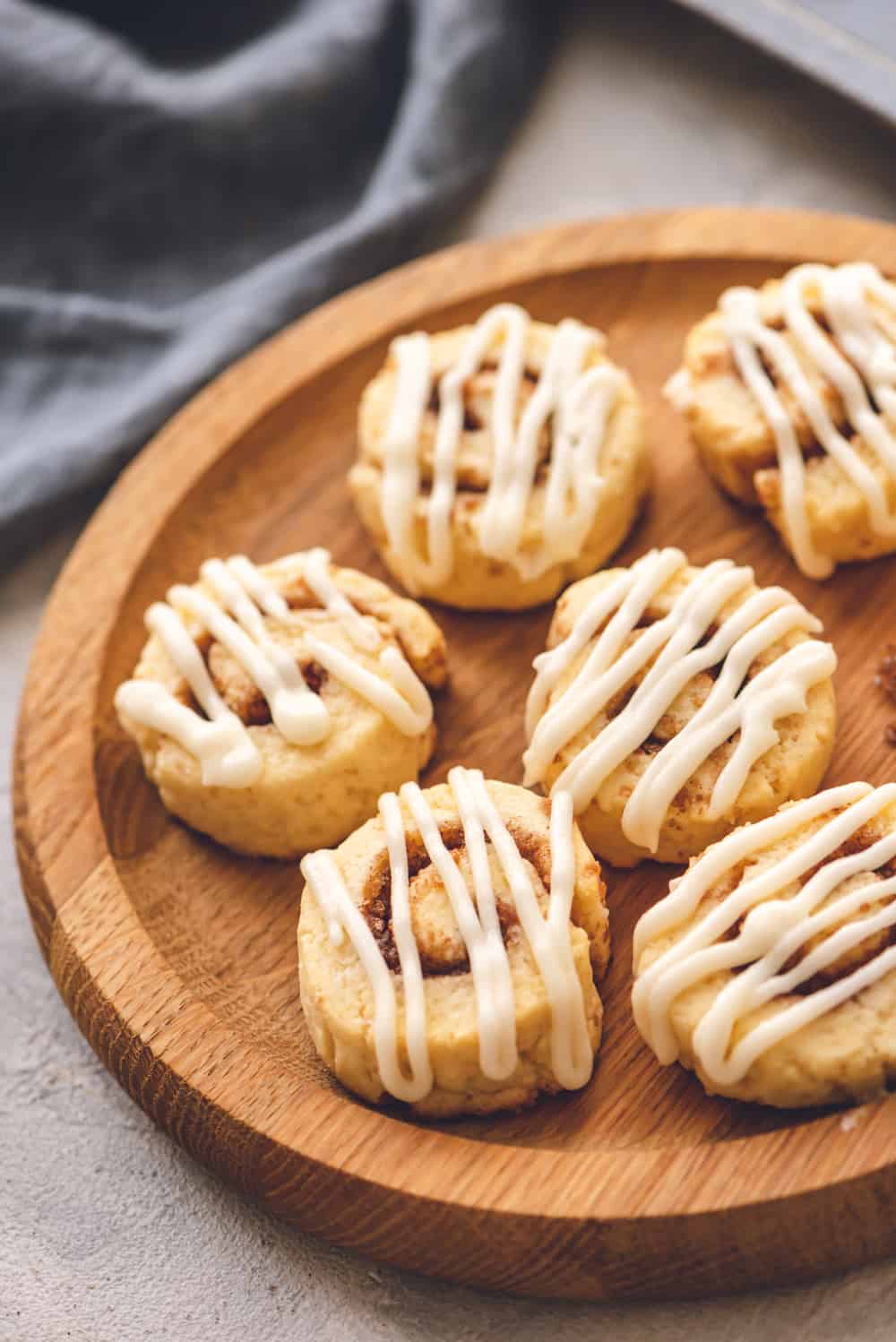 Cinnamon Roll Cookies are a sweet and savory cookie, rolled in a cinnamon buttery filling bakedย until puffy thenย drizzled with a sweet glaze frosting. Theseย holiday cookies won't last long! cinnamon roll cookies on a plate