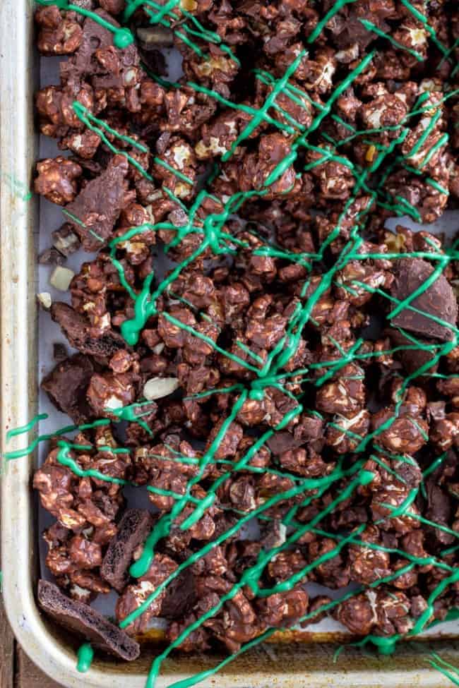 The popcorn is coated in chocolate with Andes Mint pieces and grasshopper mint cookies hidden inside. As soon as I made it I couldn't stop eating it! Grasshopper Popcorn in a cookie Sheet.