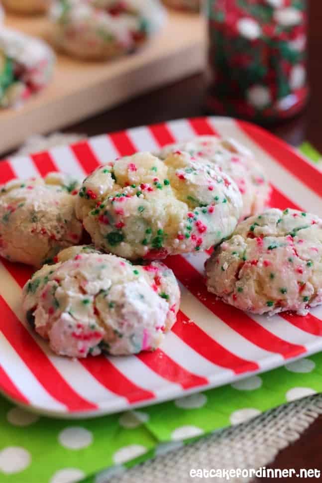 They are so soft and chewy and the powdered sugar coating makes them extra special. I chose to add almond and orange extracts, because those flavors remind me of Christmas. Christmas Gooey Butter Cookies on a white and red plate. Napkins with green with white dots under it.