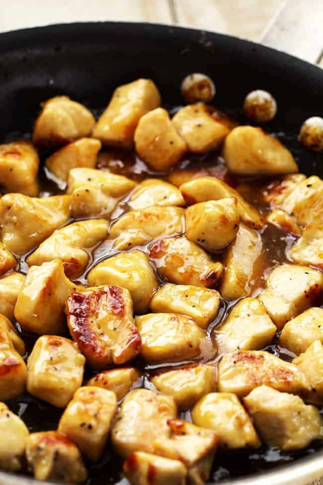 A light and delicious meal that is full of amazing honey lemon ginger flavor that the family will love! Honey lemon ginger chicken cooking in a skillet.
