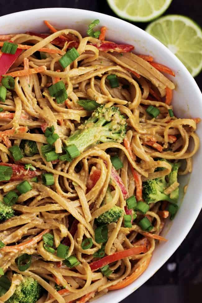 Ginger, Lime, garlic and peanut butter create a luscious Thai sauce for these whole wheat noodles! A delicious and flavorful meal that is under 400 calories! Peanut ginger noodles in a large white bowl.
