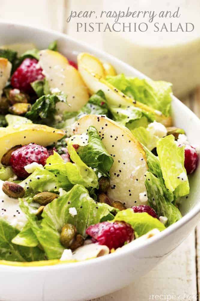 A delicious and healthy salad filled with raspberries, pears, and pistachios add a delicious flavor and crunch! Large white bowl of pear raspberry pistachio salad.