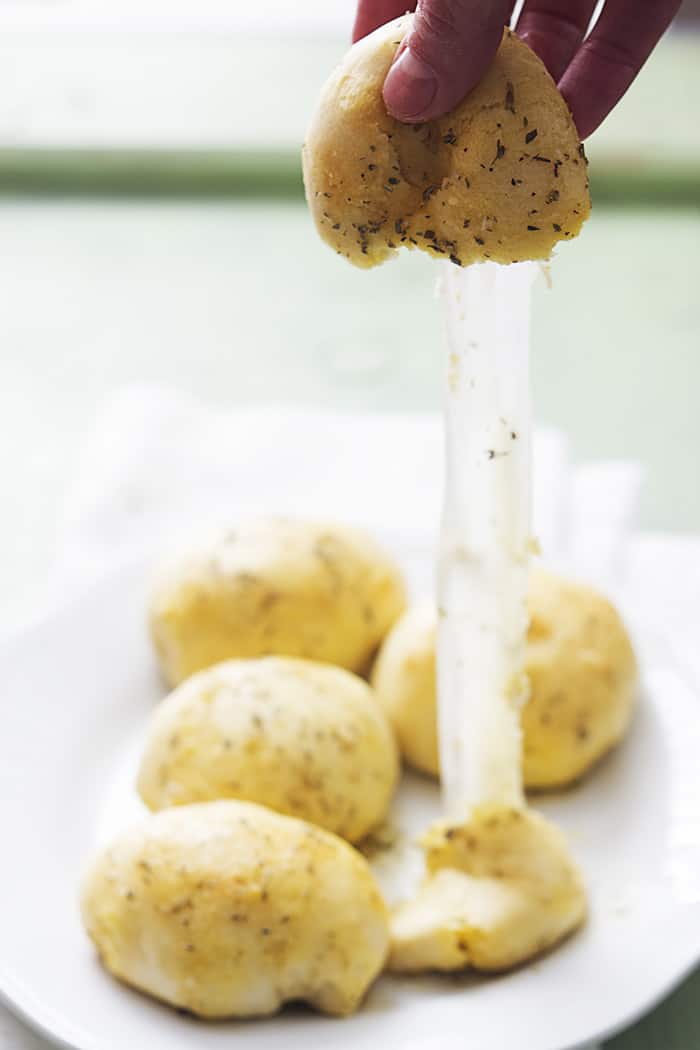 This recipe is SO easy!! Just a couple of ingredients and the whole thing takes about 15 minutes. Garlic Parmesan Cheese Bomb being pulled apart to show the gooey cheese.