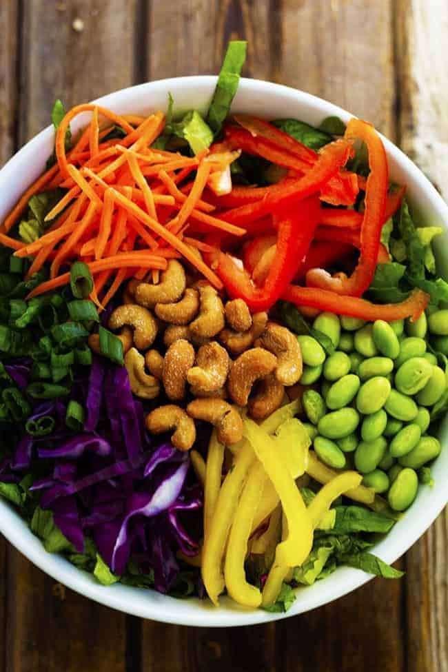 So many delicious vegetables combine in this flavorful and colorful salad! The cashews add a delicious crunch and the Ginger Peanut Sauce on top is amazing! thai salad ingredients in a bowl ready to be mixed.