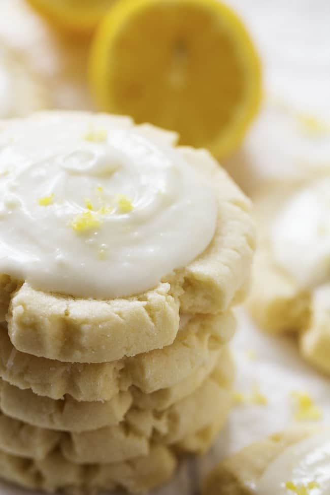 Amazingly soft and perfect lemon sugar cookies with the best lemon cream cheese frosting on top! lemon sugar cookies in a stack.