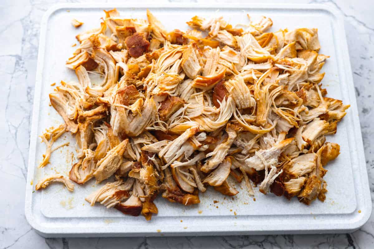 This slow cooker honey teriyaki chicken is so easy to throw together, and the flavor is out of this world! The chicken cooks to perfection and will be one of the best things you'll ever make! Overhead shot of chicken shredded on a cutting board.