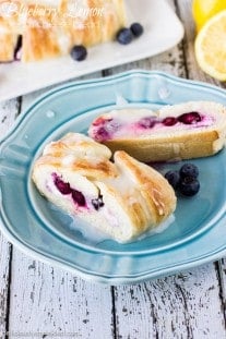 Blueberry Lemon Cream Cheese Bread is out of this world amazing! Blueberry Lemon Cream Cheese Bread on a blue plate by Deliciously Sprinkled