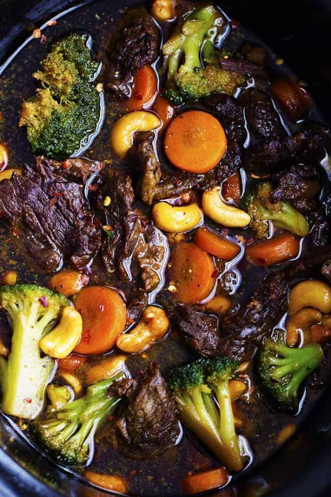 Delicious melt in your mouth beef that cooks right in your slow cooker with veggies and cashews hidden throughout. One of the best meals that you will make in your slow cooker and so much better than takeout! cashew beef and broccoli areal view in the slow cooker.