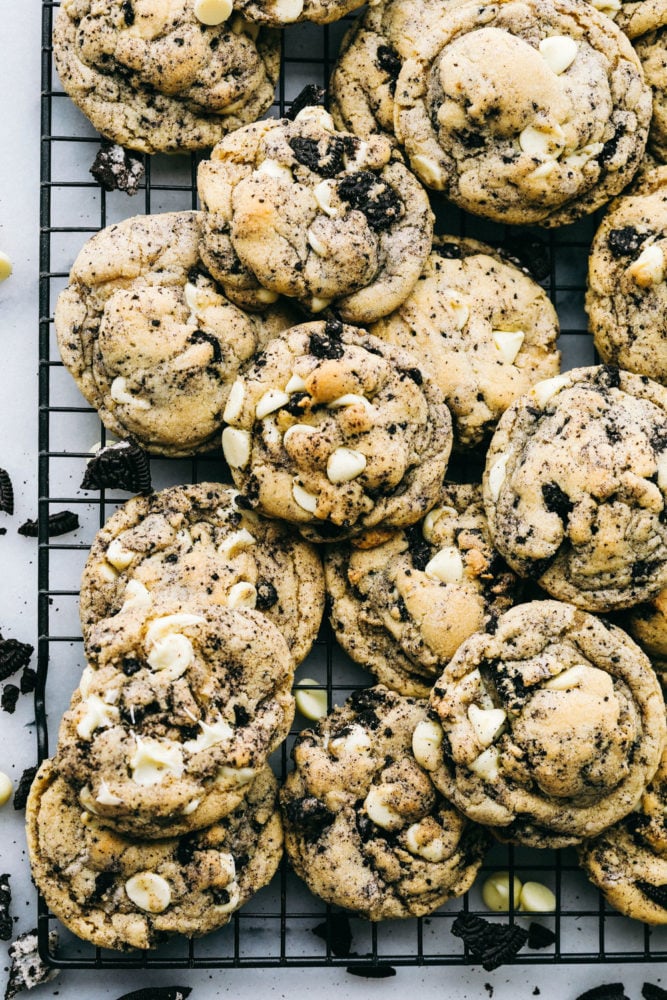 White Chocolate Oreo Cookies are perfectly soft and chewy cookies loaded with slightly melted white chocolate chips and crushed Oreo cookies. These are warm and delicious cookies with just the right amount of sweetness!ย A bunch of white chocolate oreo cookies stacked over and on top of each other on a cooling rack.
