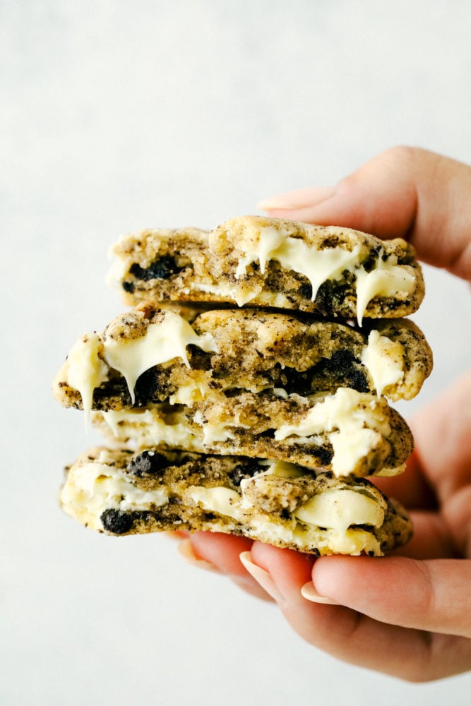 White Chocolate Oreo Cookies are perfectly soft and chewy cookies loaded with slightly melted white chocolate chips and crushed Oreo cookies. These are warm and delicious cookies with just the right amount of sweetness!ย White chocolate oreo cookies stacked on top of each other and being held up with a hand.