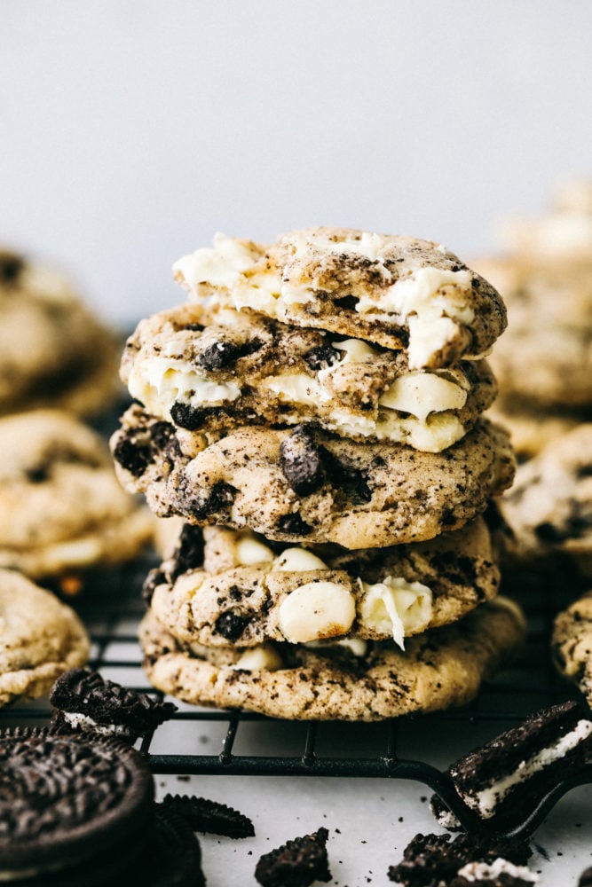 White Chocolate Oreo Cookies are perfectly soft and chewy cookies loaded with slightly melted white chocolate chips and crushed Oreo cookies. These are warm and delicious cookies with just the right amount of sweetness!ย Oreo cookies stacked on top of each other on a cooling rack garnished with oreos surrounding them.