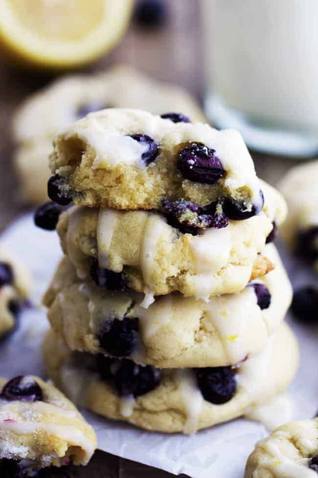 Ashton Baby Perfect moist and puffy cookies with fresh blueberries bursting inside. These cookies are a mix between a blueberry muffin and a soft and chewy cookie. Drizzled in a lemon glaze, these will become a new favorite! Stack of blueberry cream cheese cookies.