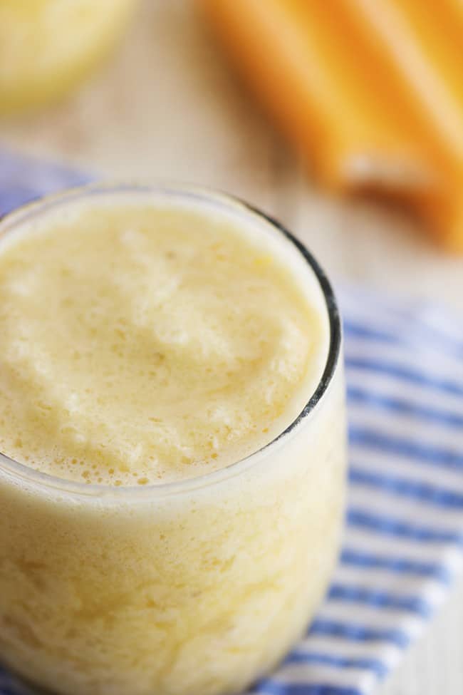 This creamy orange smoothie has no added sugar and a secret ingredient. It tastes just like you are biting into a creamsicle! The family is sure to love this one! close up of an orange creamsicle in a glass.