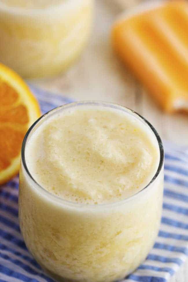 This creamy orange smoothie has no added sugar and a secret ingredient. It tastes just like you are biting into a creamsicle! The family is sure to love this one! orange creamsicle smoothie in a glass.