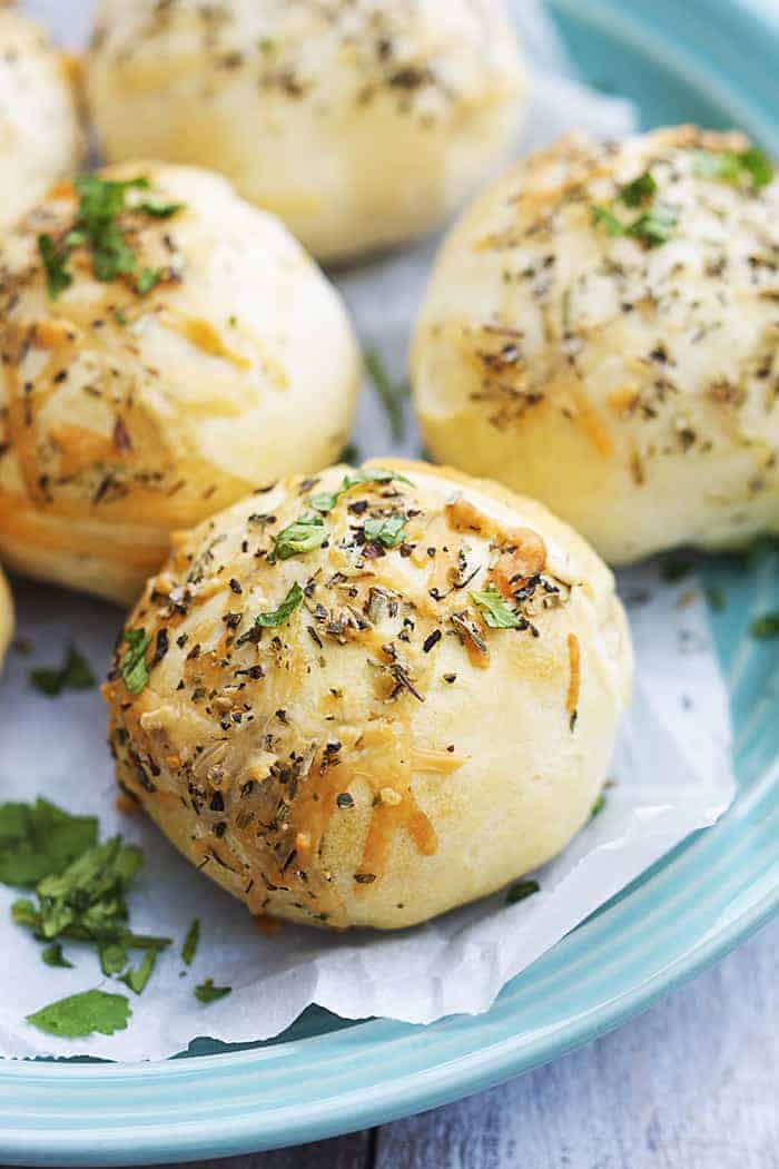 These cheesy pepperoni bombs are perfect for a snack or appetizer… or if you’re like me, for dinner! pepperoni bombs close up on a blue plate.