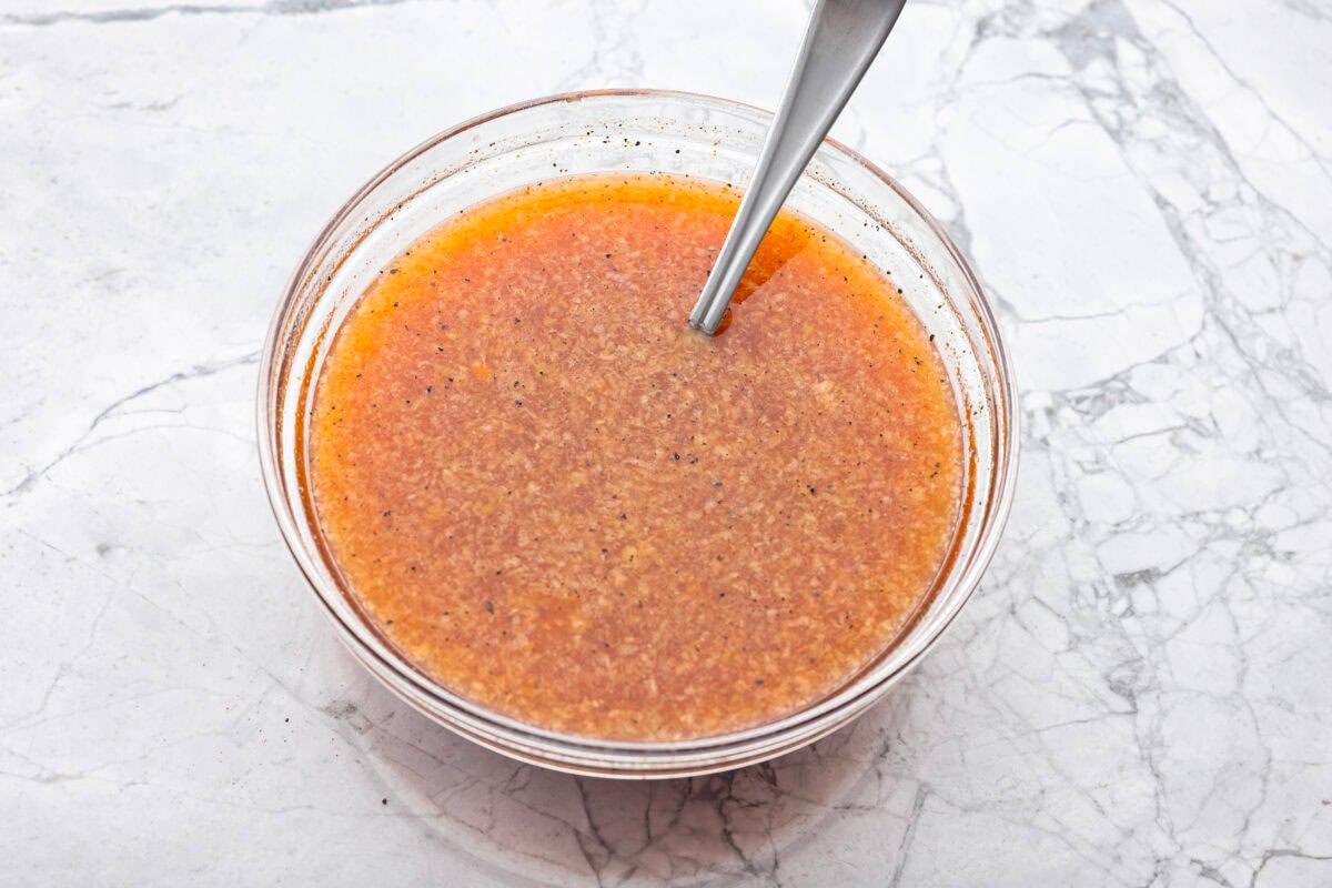 My spicy Slow Cooker Honey Sriracha Chicken is moist, tender, and out-of-this-world delicious with the sweet and spicy sauce! If you love sriracha, you'll love this! Sauce ingredients whisked together in a bowl.