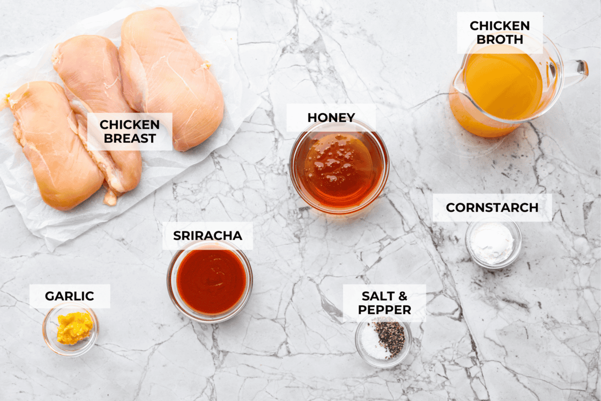My spicy Slow Cooker Honey Sriracha Chicken is moist, tender, and out-of-this-world delicious with the sweet and spicy sauce! If you love sriracha, you'll love this! Overhead shot of labeled ingredients.