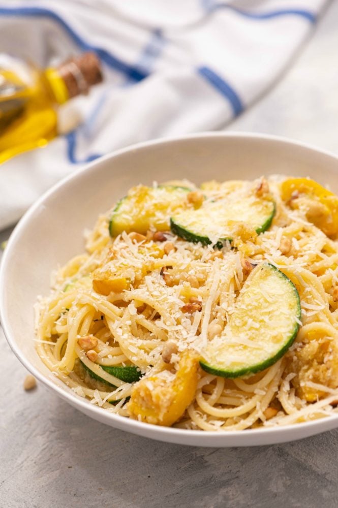Summer squash lemon spaghetti is an amazing vegetable pasta recipe that is so simple, but also so completely satisfying! The flavors are bright and fresh and the fragrance is soooo vibrant! Summer squash lemon spaghetti in a white bowl.