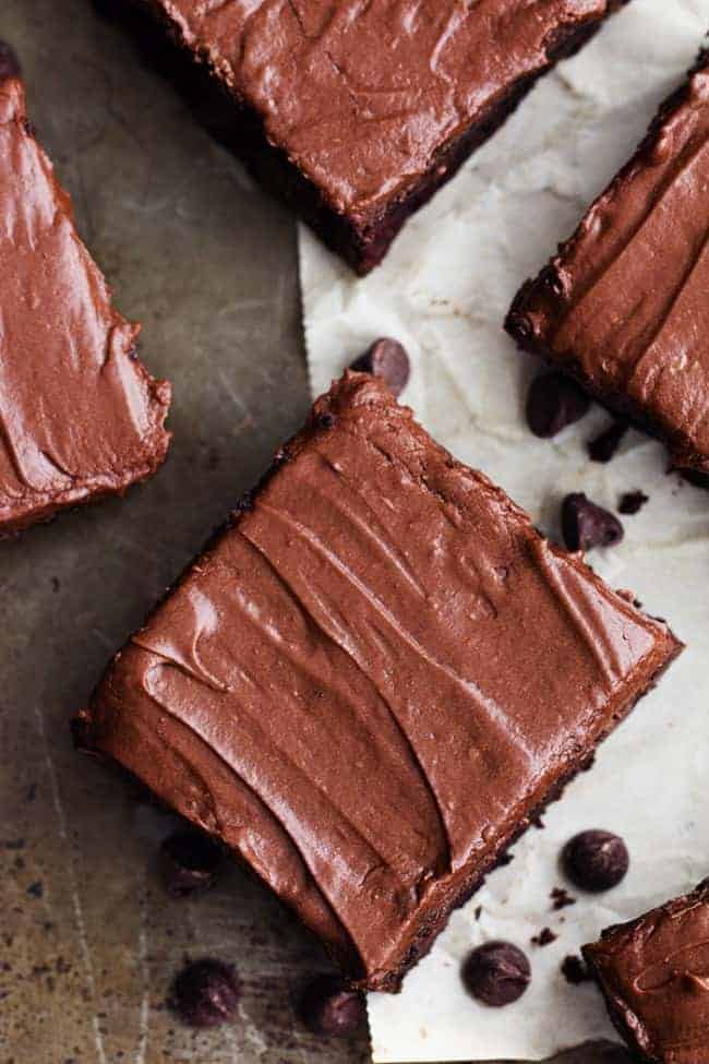 Perfectly moist and chocolatey brownies filled with chocolate chips and topped withย chocolateย frosting. Simple and delicious and you won't even be able to tell that 2 cups of zucchini is hidden inside!ย Areal view of double chocolate zucchini brownies.