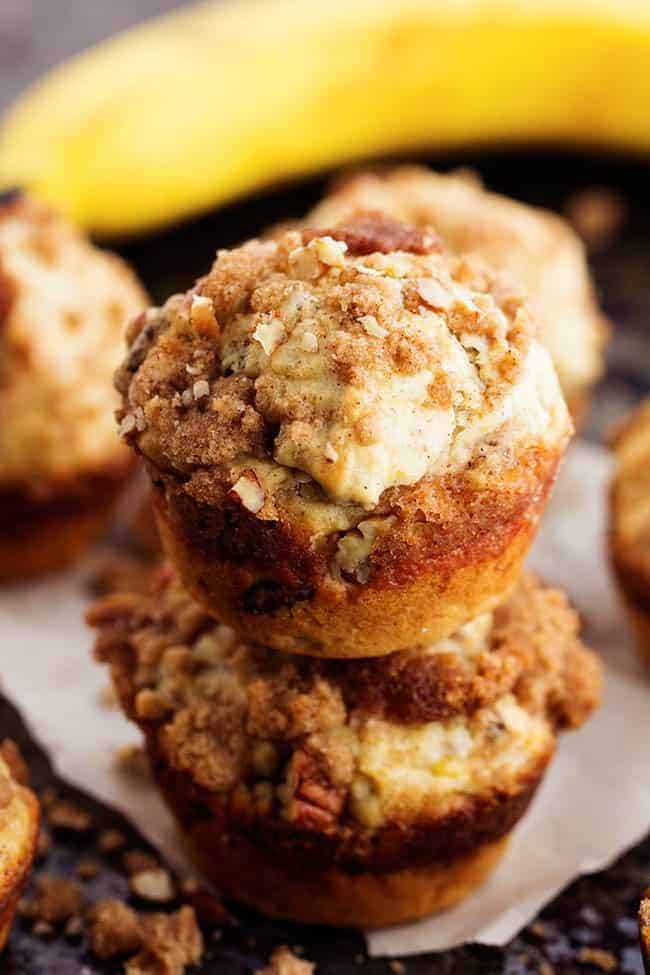 Moist and delicious banana muffins with a crumbly cinnamon streusel topping. This is such a yummy way to use up those over ripe bananas! Stack of 2 banana bread muffins.