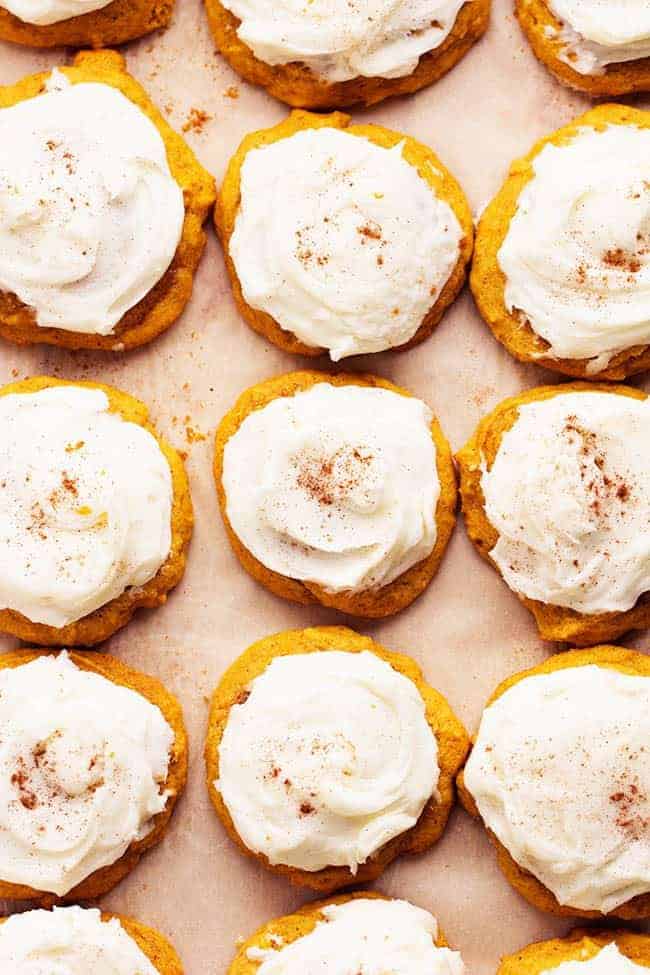 Delicious and soft pumpkin cookies that just melt in your mouth! These are the BEST pumpkin cookies and the cream cheese frosting on top is fantastic! Areal view of pumpkin cookies in a row.