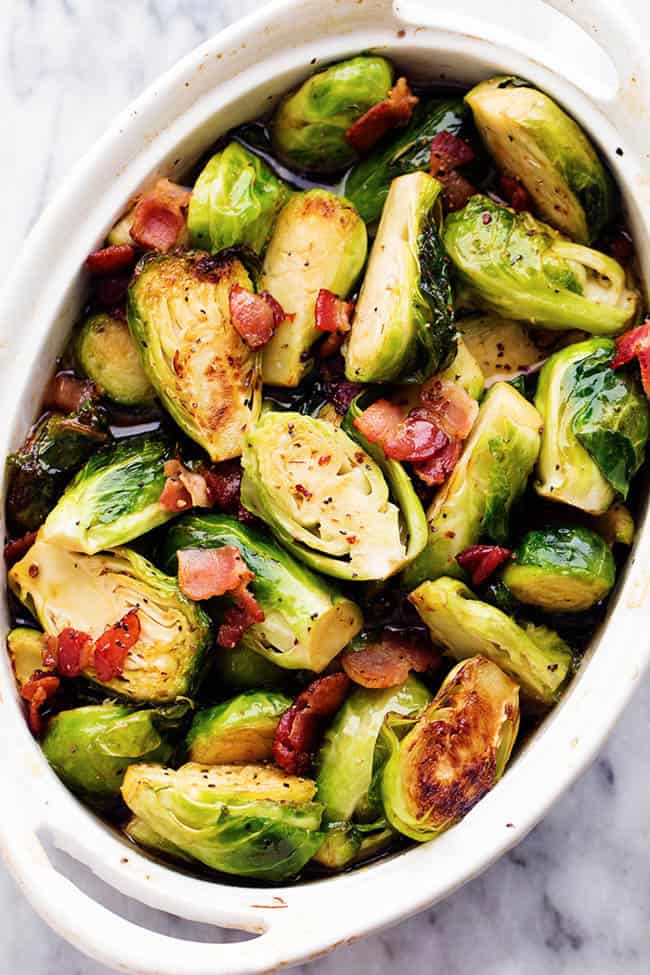 The sweet maple glaze and bacon complement these roasted brussel sprouts perfectly. This will be a side dish that the family won't be able to get enough of! brussel sprouts in a white dish.