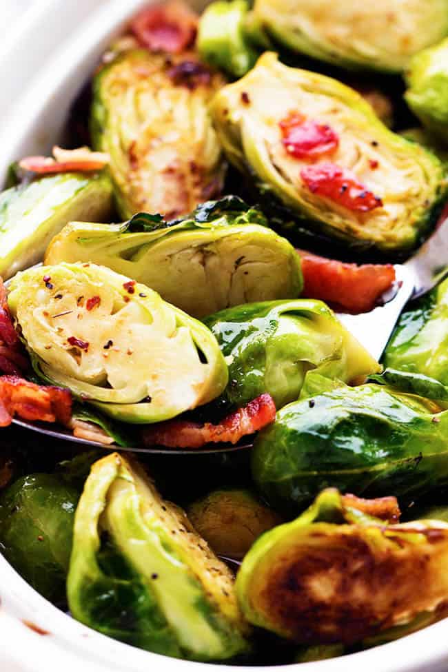 The sweet maple glaze and bacon complement these roasted brussel sprouts perfectly. This will be a side dish that the family won't be able to get enough of! brussel sprouts in a white dish.