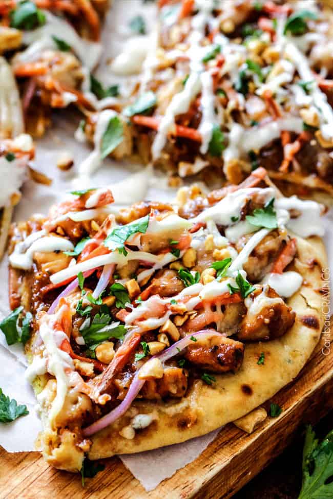 Thai Chicken Flatbread Pizza smothered in easy tangy peanut sauce, tender chicken, ย carrots, sprouts, mozzarella cheese and the option of Coconut Crema drizzle - an amazing flavor bursting quick dinner the whole family will love! Thai Chicken Flatbread Pizza slices.