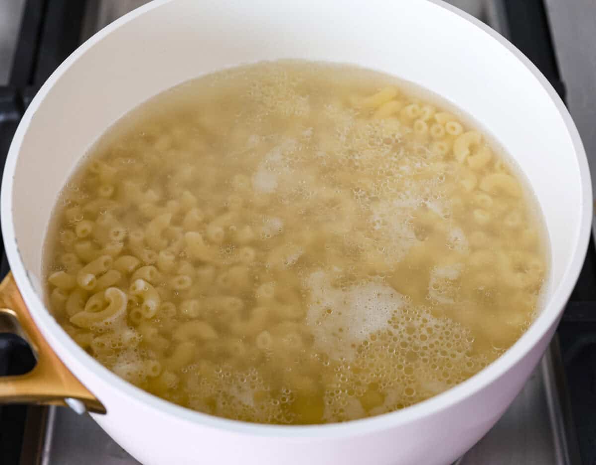 This cheesy butternut squash pasta recipe is loaded with cozy fall squash and ooey, gooey cheese,ย making it a perfect meal to warm up to on crisp fall evenings. Even better, it can be ready in less than an hour! Angle shot of pasta cooking in a pot on the stove.
