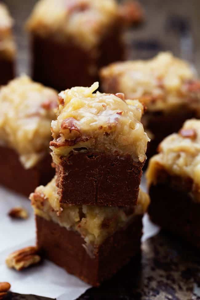 A quick and easy chocolate fudge that doesn't require a thermometer. Topped with the signature coconut pecan frosting, this fudge is out of this world!ย german chocolate fudge squares in a stack.