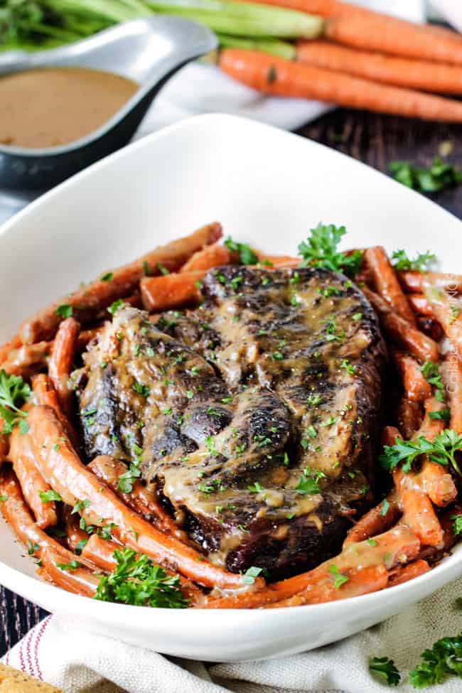 Fall apart juicy, tender roast with hardly any hands-on prep time is easy enough for everyday, delicious enough for company! Roast and carrots in a white serving bowl.