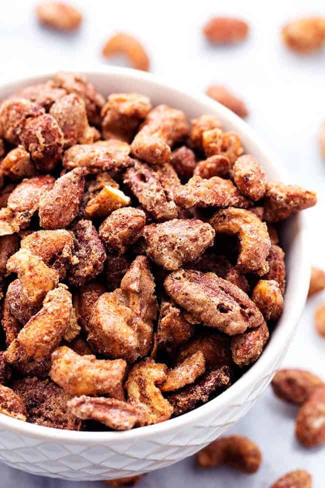 These slow roasted almonds, cashews, and pecans areย coated in aย sugar glaze spiced withย cinnamon making an addicting snack for any occasion! They also make amazing neighbor gifts! cinnamon nuts in a white bowl.