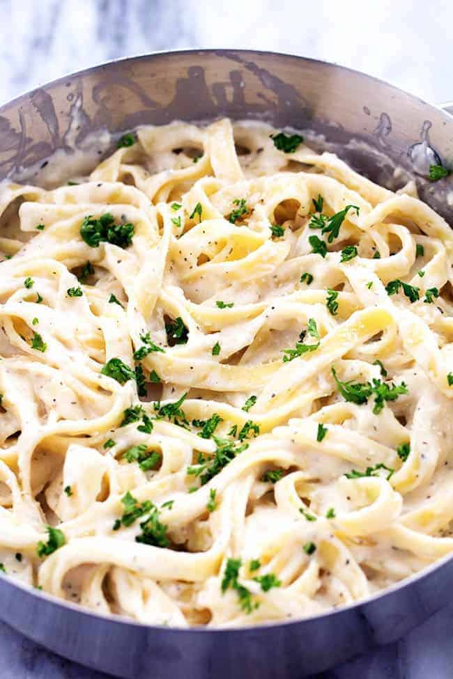 A lightened up garlic alfredo sauce that is delicious and creamy and coats the pasta perfectly! Half of the calories and you won't even be able to tell! Skinny alfredo pasta in a pan.