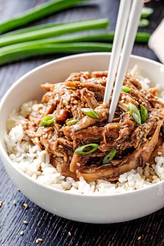 Slow Cooker Honey Soy Chicken is so easy and so delicious you will be wondering how you ever lived without it! Honey Soy Chicken over white rice in white bowl.