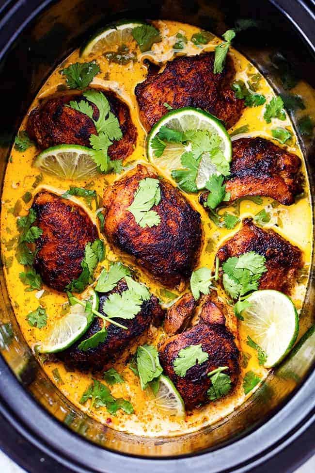 Tender and juicy seasoned and pan seared chicken thighs slow cook with a flavorful and light cilantro lime sauce. ย This meal is packed with flavor and absolutely delicious!ย Overhead view of Slow Cooker Creamy Cilantro Lime Chicken.