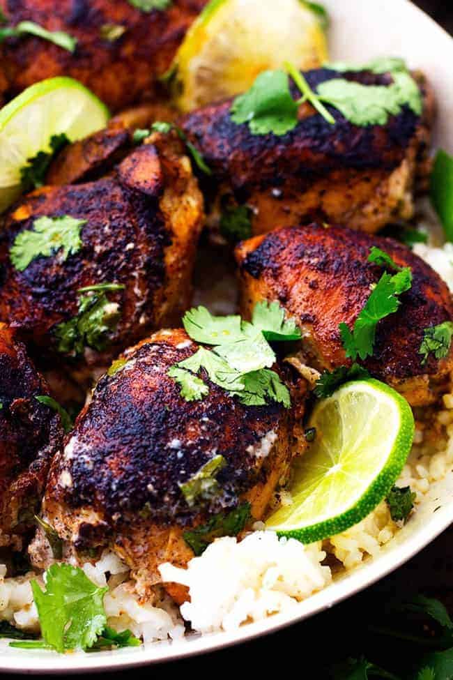 Tender and juicy seasoned and pan seared chicken thighs slow cook with a flavorful and light cilantro lime sauce. ย This meal is packed with flavor and absolutely delicious!ย Slow Cooker Creamy Cilantro Lime Chicken in a white bowl over rice.