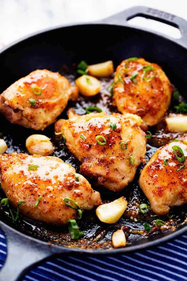 A quick and easy 30 minute meal that is packed with amazing honey dijon garlic flavor! The chicken is so juicy and tender and the sauce is sweet and tangy... you are going to love it! Chicken in frying pan with garlic and onion.