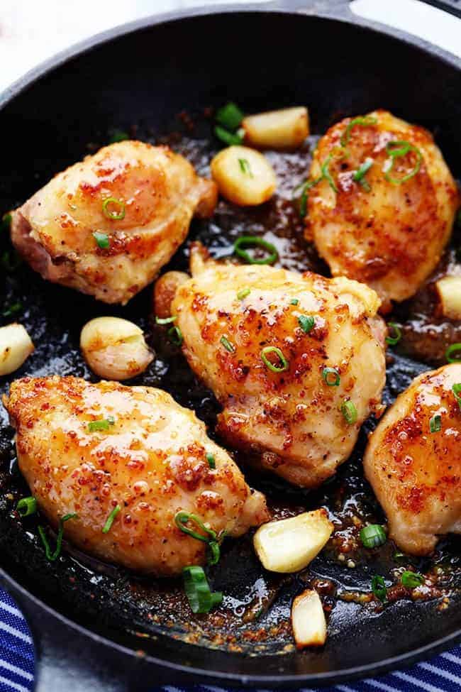 A quick and easy 30 minute meal that is packed with amazing honey dijon garlic flavor! The chicken is so juicy and tender and the sauce is sweet and tangy... you are going to love it! Chicken in a frying pan with garlic and onion.