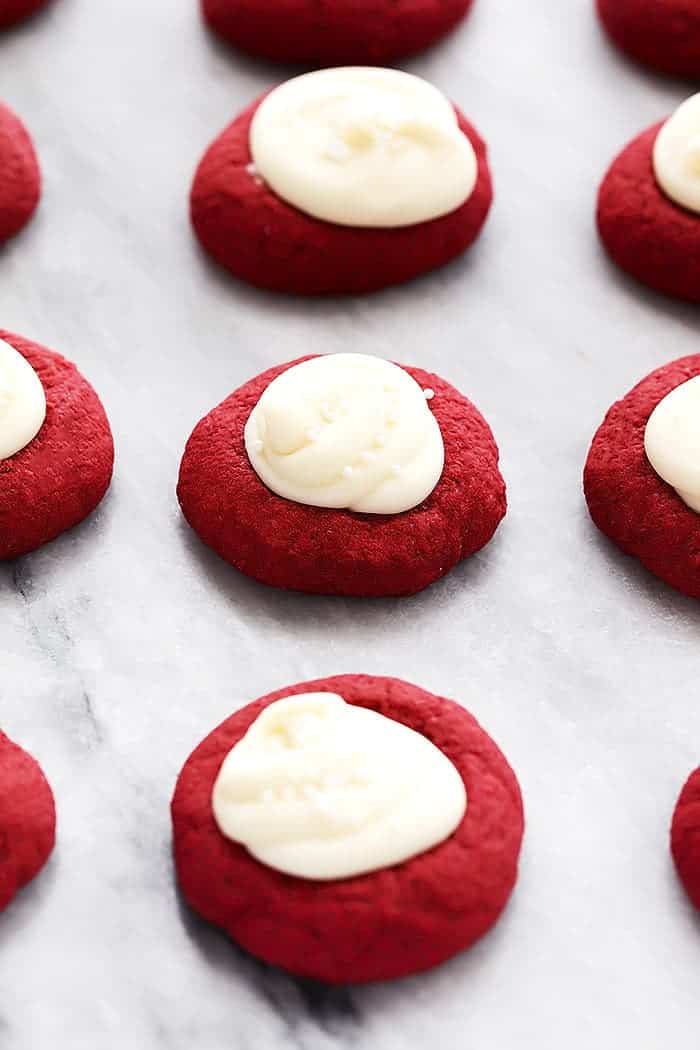 These thumbprint cookies are buttery pillows of dreamy cookie goodness filled with rich cream cheese frosting and I have eaten WAY too many of them. Red velvet cookies with cream cheese filling.
