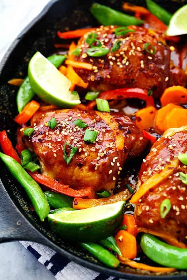 A 30 minute one skillet meal that is full of amazing flavor and veggies! The thai peanut sauce glazes the chicken perfectly and this will be a hit for dinner! Thai Peanut Skillet Chicken with lime and other fresh vegetables.