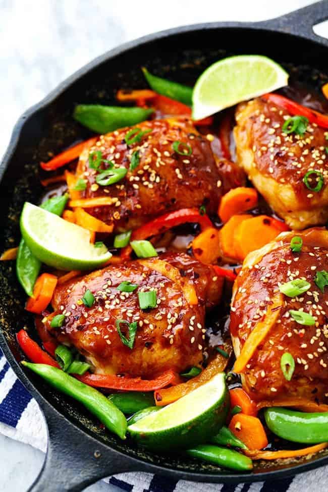 A 30 minute one skillet meal that is full of amazing flavor and veggies! The thai peanut sauce glazes the chicken perfectly and this will be a hit for dinner! Thai Peanut Skillet Chicken with lime and other vegetables.