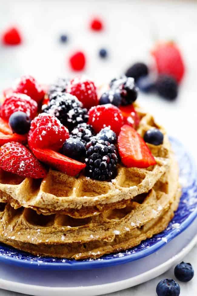 Delicious and healthy whole wheat waffles that are packed with protein and nutrients. Skinny Protein Waffles with fresh berries on top on blue plate
