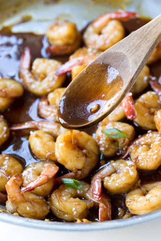 Super Easy Teriyaki Shrimp. Tender shrimp sautéed in a homemade teriyaki sauce. Takes less than 15 minutes to make! Teriyaki shrimp in a skillet with a wooden spoon.