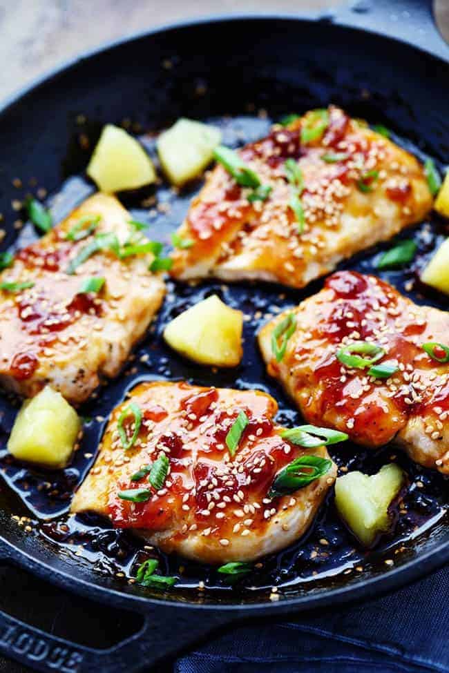 A sweet teriyaki sauce infused with pineapple and ginger bringing such an amazing marinade for this chicken! ย A quick 30 minute meal that you will make again and again!ย Teriyaki Chicken in black bowl with pineapple and onion.